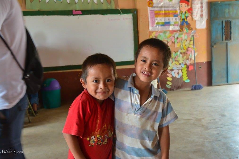 Mateo and a friend smiling in their classroom in rural Guatemala